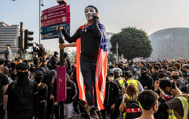 NEW YORK TIMES
                                A masked protester wrapped in an American flag during a demonstration in the Tsim Sha Tsui neighborhood of Hong Kong, Dec. 1, 2019. After a relative lull in the protests, thousands of pro-democracy activists turned out Sunday for three demonstrations a week after scoring a major victory in elections that were viewed as a broad endorsement of the movement’s goals. (Lam Yik Fei/The New York Times)