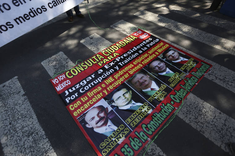 ASSOCIATED PRESS
                                A poster with former Mexican presidents lays on the ground outside the Supreme Court during a demonstration by supporters of Mexico’s current President Andres Manuel Lopez Obrador in Mexico City.