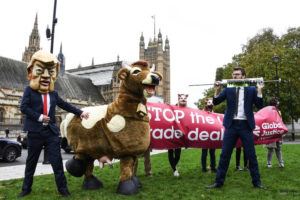 ASSOCIATED PRESS
                                A man imitates the injection of hormones into a man in a cow costume, in Parliament Square, as part of a day of action against the U.S. trade deal, ten days before the presidential election.