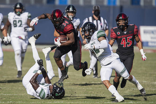 ASSOCIATED PRESS
                                San Diego State running back Greg Bell, center, leaps over Hawaii defensive back Quentin Frazier, bottom left, during the first half today in Carson, Calif.