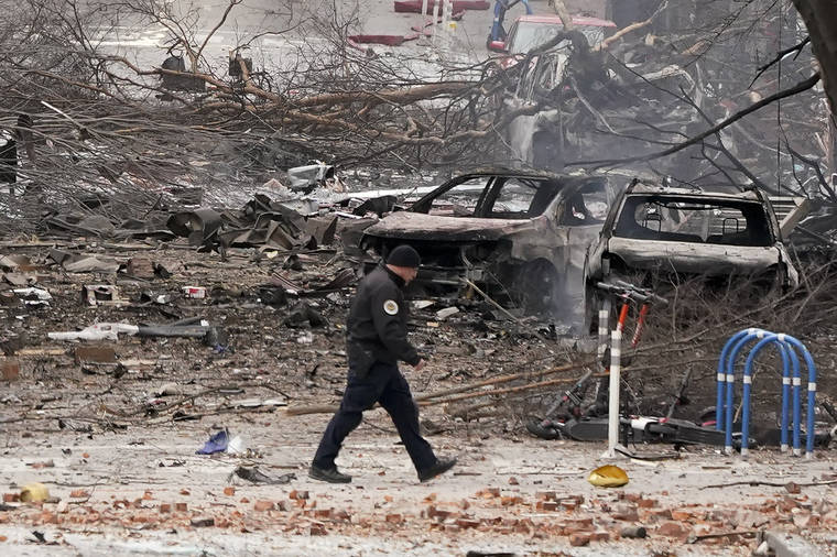 ASSOCIATED PRESS
                                A law enforcement member walks past damage from an explosion in downtown Nashville, Tenn. Buildings shook in the immediate area and beyond after a loud boom was heard early Christmas morning.