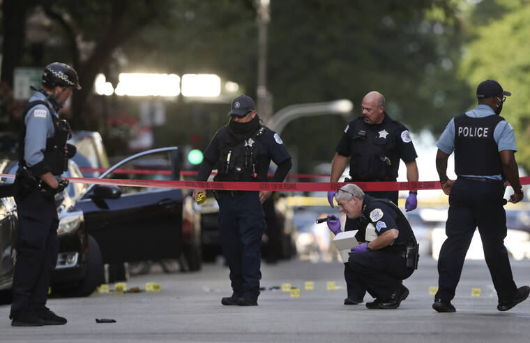 CHRIS SWEDA/CHICAGO TRIBUNE VIA AP / 2020
                                Chicago police investigate the scene of a shooing in Chicago. Five alleged gang members have been indicted on murder charges in last year’s shooting death of Chicago rapper Carlton Weekly, also known as “FBG Duck,” in the fashionable Gold Coast neighborhood, that prosecutors say was part of an ongoing violent effort to protect gang territories on the city’s South Side, officials announced.