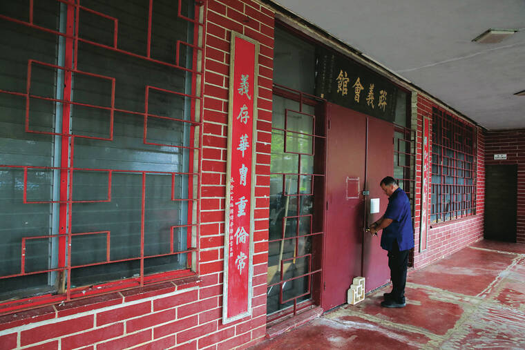 JAMM AQUINO / JAQUINO@STARADVERTISER.COM
                                Robert Wong opens the door to the Memorial Hall, built in the 1940s.