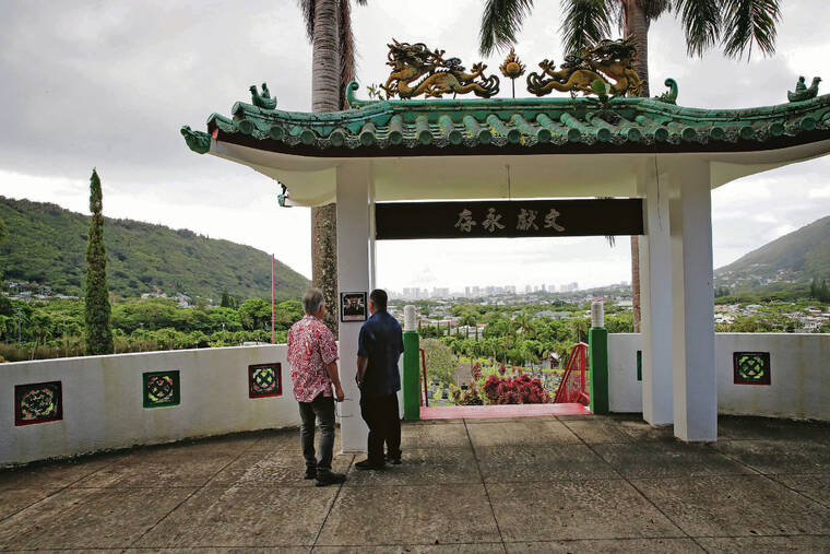 JAMM AQUINO / JAQUINO@STARADVERTISER.COM
                                Grounds superintendent Robert Wong, above right, and trustee Les Young view a plaque listing the committee members who financed improvements to the Grand Ancestors Tomb platform and other projects in 1997.