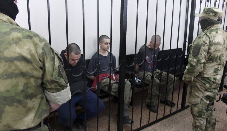 ASSOCIATED PRESS
                                Two British citizens Aiden Aslin, left, and Shaun Pinner, right, and Moroccan Saaudun Brahim, center, sit behind bars in a courtroom in Donetsk, in the territory which is under the Government of the Donetsk People’s Republic control, eastern Ukraine, today. The two British citizens and a Moroccan have been sentenced to death by pro-Moscow rebels in eastern Ukraine for fighting on Ukraine’s side. The three men fought alongside Ukrainian troops and surrendered to Russian forces weeks ago.