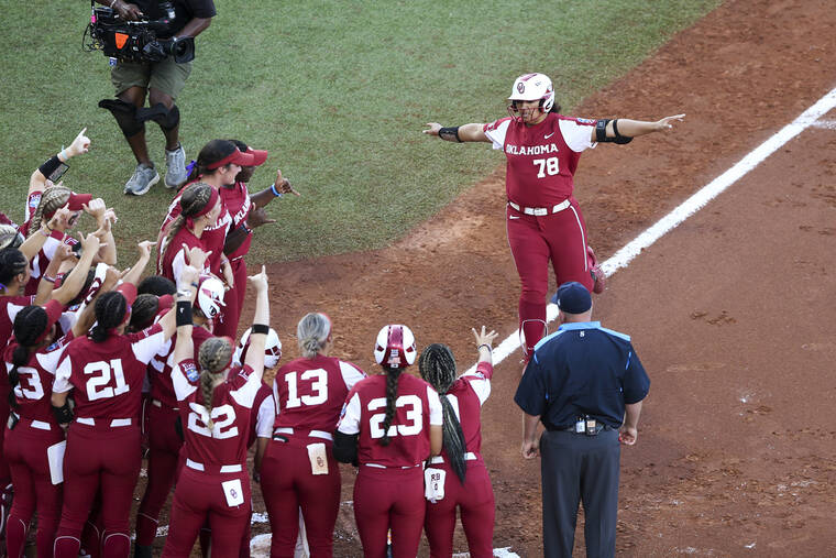 TULSA WORLD VIA AP Oklahoma players cheer for Jocelyn Alo, who approaches home after hitting a home run against Texas during the first inning.