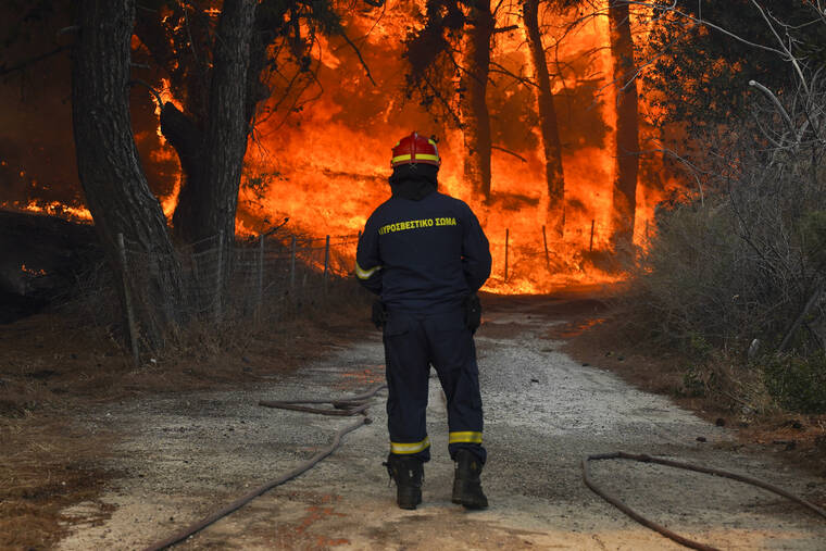 YORGOS KARAHALIS / AP
                                A firefighter tries to extinguishes a forest fire near the beach resort of Vatera, on the eastern Aegean island of Lesvos, Greece, Saturday.