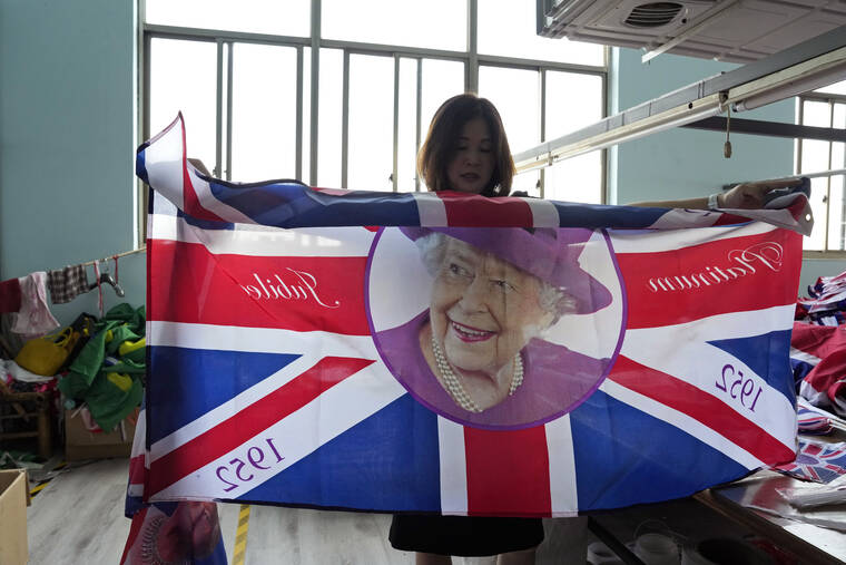 ASSOCIATED PRESS / SEPT. 16
                                General manager Fan Aiping holds up one of the flag with the Queen’s image at the Shaoxing Chuangdong Tour Articles Co. factory in Shaoxing, in eastern China’s Zhejiang province. Ninety minutes after Queen Elizabeth II died, orders for thousands of British flags started to flood into the factory south of Shanghai.