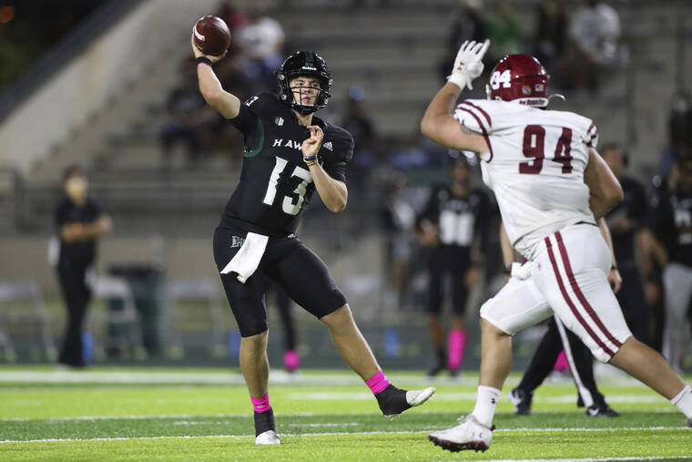 ASSOCIATED PRESS / 2021 Hawaii quarterback Brayden Schager threw a pass over New Mexico State defensive lineman Justin Segura during a game last season at Clarence T.C. Ching Athletic Complex.