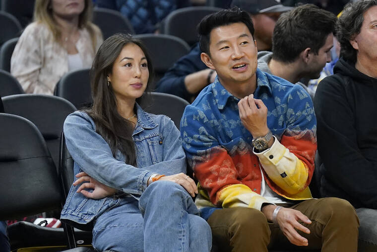 ASSOCIATED PRESS
                                Actor Simu Liu, right, watches an NBA basketball game between the Golden State Warriors and the Miami Heat in San Francisco, in October 2022. Marvel Shang-Chi actor Liu wants everyone who attends an event at Chase Center to feel welcome, comfortable and supported, just as he has been in the five months since opening up about his own challenges with anxiety.