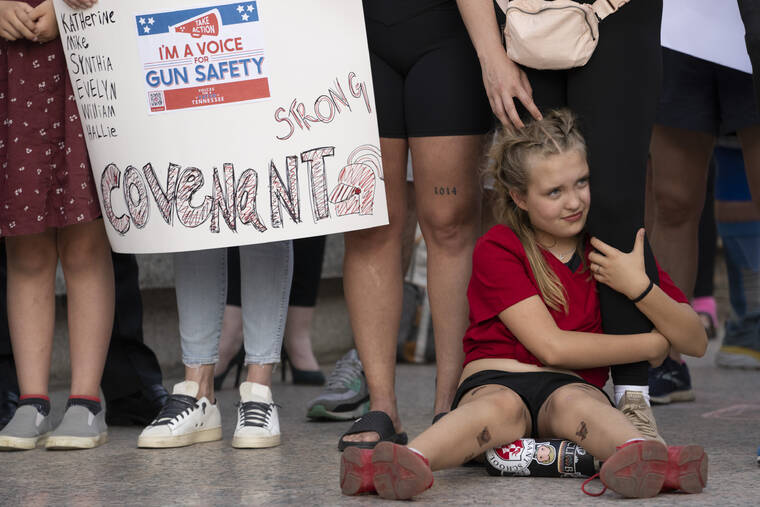 GEORGE WALKER IV / AP
                                Covenant School student Alex Eissinger-Hansen holds her mother’s leg during a demonstration for gun control legislation Tuesday, April 18, in Nashville, Tenn. Participants created a human chain spreading from Monroe Carell Jr. Children’s Hospital at Vanderbilt, where victims of The Covenant School shooting were taken on March 27, to the Tennessee State Capitol.