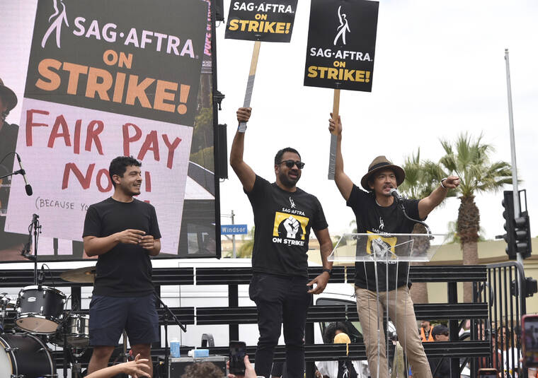 INVISION / AP
                                Kal Penn, center, and John Cho, right, speak during a rally outside Paramount Pictures Studio on Wednesday in Los Angeles.