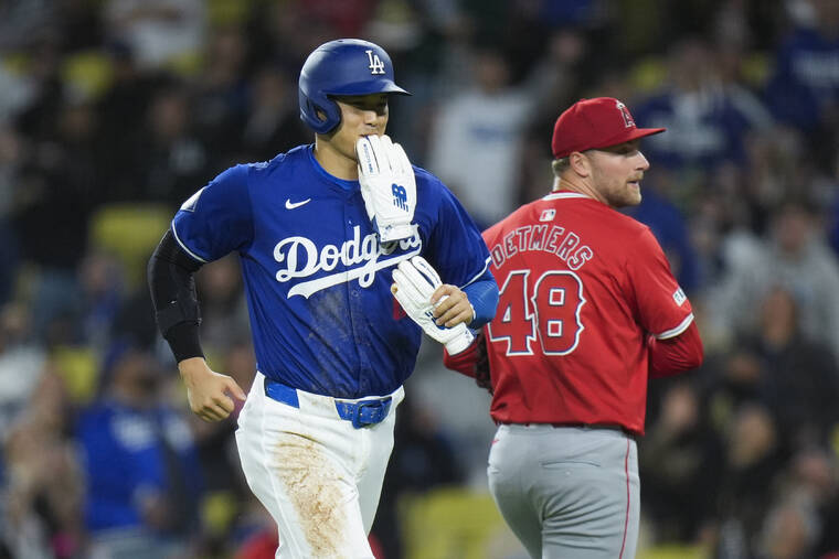 ASSOCIATED PRESS
                                Los Angeles Dodgers’ Shohei Ohtani, left, smiles as he heads toward the dugout past Los Angeles Angels starting pitcher Reid Detmers after the fifth inning on Monday.