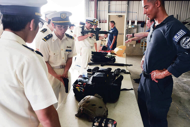 KEVIN KNODELL / KKNODELL@STARADVERTISER.COM
                                Above, members of the U.S. Coast Guard’s Marine Patrol Division showed off tactical gear to visiting cadets from the Japanese Coast Guard Academy during a visit Wednesday to the U.S. Coast Guard Base at Sand Island.