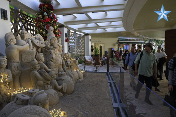 Hotel guests admire holiday sand sculptures at the Sheraton Waikiki