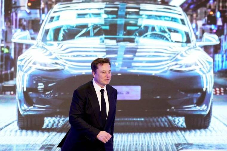 REUTERS/ALY SONG//FILE PHOTO
                                Tesla Inc CEO Elon Musk walks next to a screen showing an image of the Tesla Model 3 car during an opening ceremony for the Tesla China-made Model Y program in Shanghai, China, in January 2020.